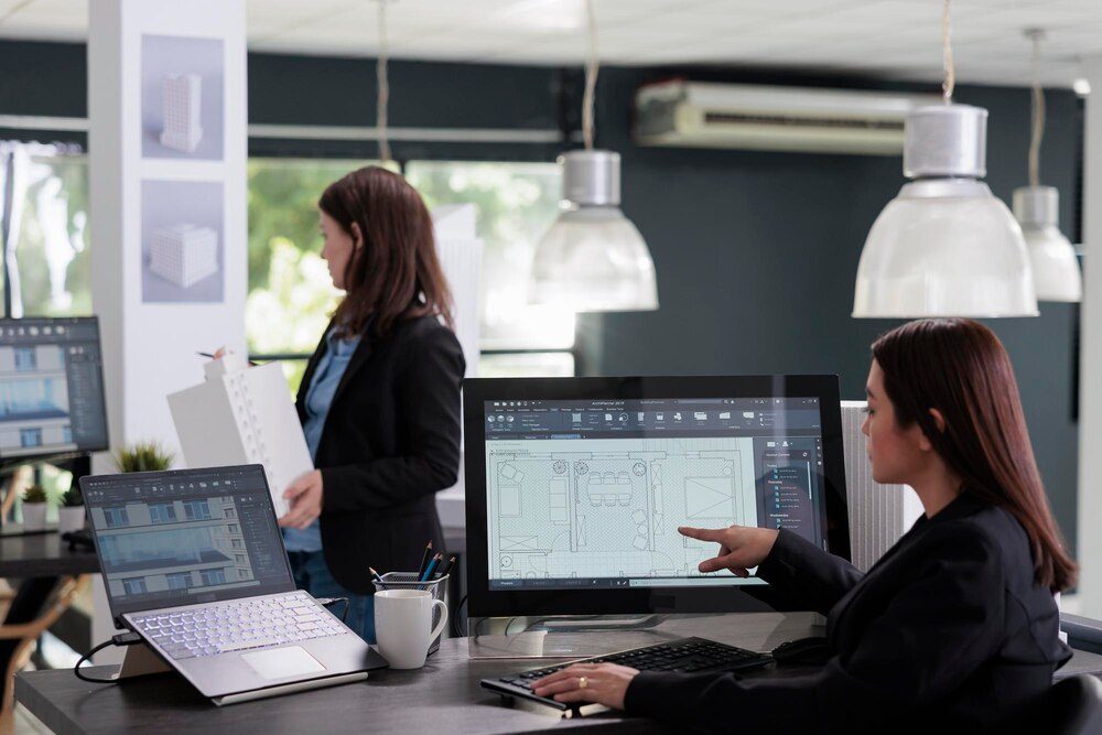 A real estate team working with floor plans and software in the office