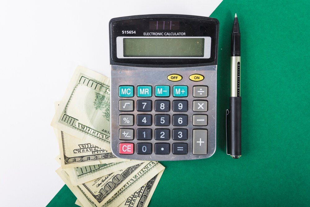 Calculator and money on the table while calculating a website budget in Mexico