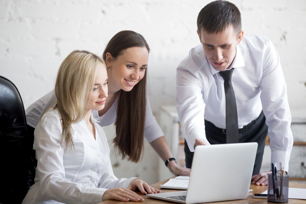 Equipo de negocio trabajando en un proyecto con ordenadores en oficina