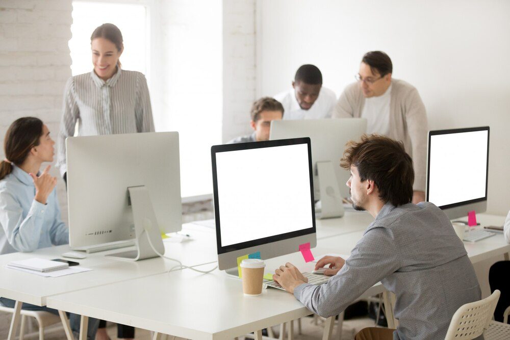 Grupo de empleados trabajando con ordenadores en una oficina moderna