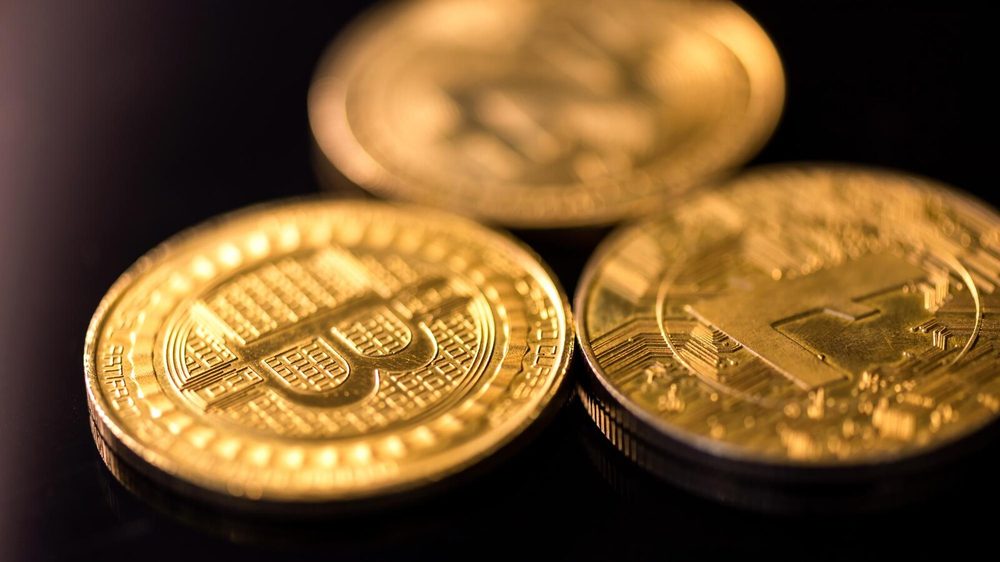 Monedas de bitcoin y gráficas de cotización en pantalla